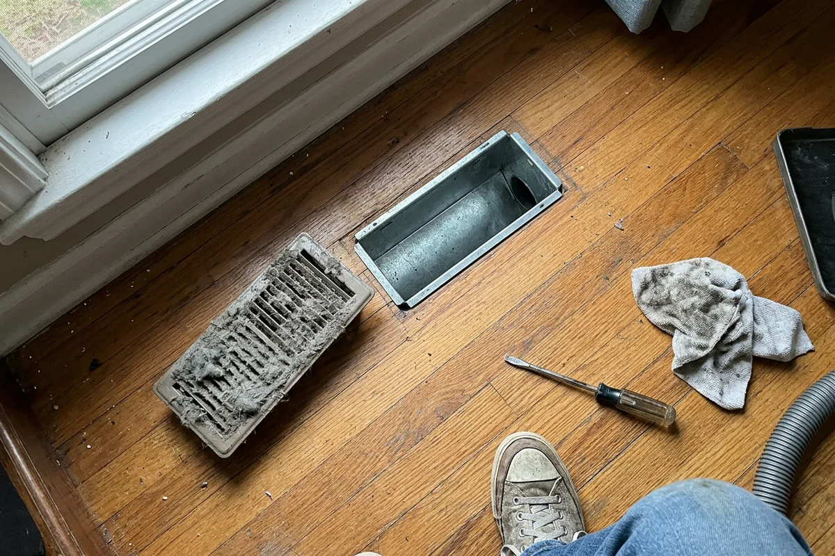 Floor vent register removed to show the duct opening before and after cleaning